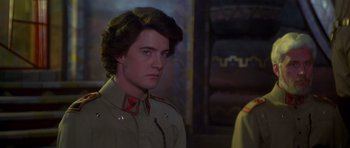 Movie still from “Dune” (1984), directed by David Lynch – A man in a military uniform looking at the camera; Close Up shot, Over the shoulder angle