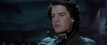 Movie still from “Dune” (1984), directed by David Lynch – A person wearing a neck brace; Close Up shot, Low angle