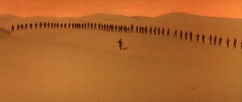 Movie still from “Dune” (1984), directed by David Lynch – A group of people standing on top of a sand dune; Extreme Wide shot, High angle