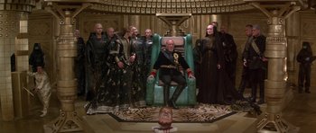 Movie still from “Dune” (1984), directed by David Lynch – A group of people standing next to each other in a room; Wide shot, High angle