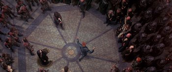 Movie still from “Dune” (1984), directed by David Lynch – A group of people sitting on the ground in a room; Extreme Wide shot, Overhead angle