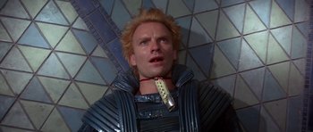 Movie still from “Dune” (1984), directed by David Lynch – A person wearing a suit and tie; Close Up shot, Overhead angle