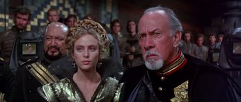 Movie still from “Dune” (1984), directed by David Lynch – A man and a woman in medieval garb in front of a group of people; Close Up shot, Over the shoulder angle