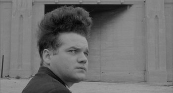 Movie still from “Eraserhead” (1977), directed by David Lynch – A black and white photo of a man with a mohawk; Close Up shot, Low angle