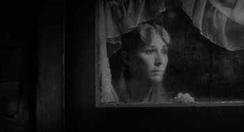 Movie still from “Eraserhead” (1977), directed by David Lynch – A black and white photo of a woman looking out of a window; Close Up shot, High angle