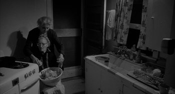 Movie still from “Eraserhead” (1977), directed by David Lynch – An older woman and a younger woman in a kitchen; Medium shot, High angle