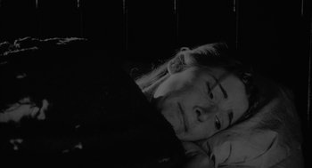 Movie still from “Eraserhead” (1977), directed by David Lynch – A woman laying in bed with her head resting on the pillow; Close Up shot, High angle