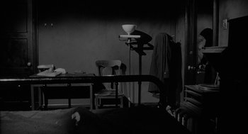 Movie still from “Eraserhead” (1977), directed by David Lynch – A black and white photo of a room with furniture; Wide shot, High angle