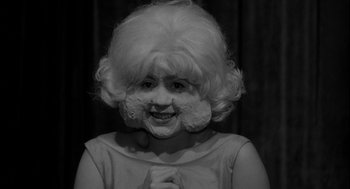 Movie still from “Eraserhead” (1977), directed by David Lynch – A woman with a white wig on her face; Close Up shot, Over the shoulder angle