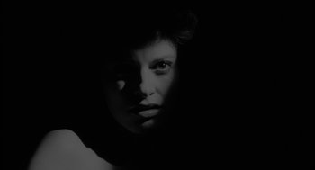 Movie still from “Eraserhead” (1977), directed by David Lynch – A black - and - white photo of a woman's face in the dark; Close Up shot, Low angle