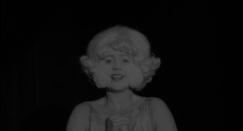 Movie still from “Eraserhead” (1977), directed by David Lynch – A black and white photo of a woman in a wig; Close Up shot, High angle