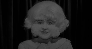 Movie still from “Eraserhead” (1977), directed by David Lynch – A black and white photo of a woman with a white wig; Close Up shot, Low angle