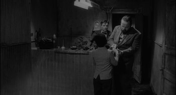 Movie still from “Eraserhead” (1977), directed by David Lynch – Two men and a boy in a room; Medium shot, Over the shoulder angle