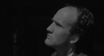 Movie still from “Eraserhead” (1977), directed by David Lynch – Black and white photograph of a man's head looking up; Close Up shot, Low angle