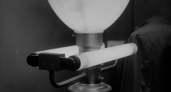 Movie still from “Eraserhead” (1977), directed by David Lynch – A light fixture with a black background; Extreme Close Up shot, Low angle