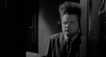 A black and white photo of a man with a strange haircut
