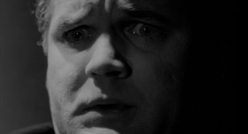 Movie still from “Eraserhead” (1977), directed by David Lynch – Black and white photograph of a man's face; Extreme Close Up shot, Low angle