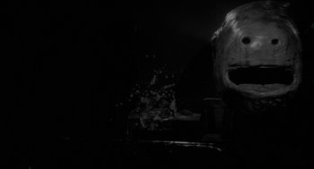 Movie still from “Eraserhead” (1977), directed by David Lynch – A black and white photo of a dark room; Close Up shot, Low angle