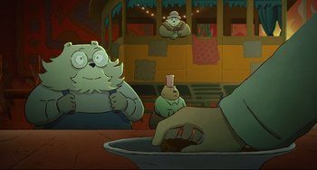 Movie still from “Ernest and Celestine: A Trip to Gibberitia” (2022), directed by Jean-Christophe Roger – A group of people sitting at a table with a bowl; Medium shot, Over the shoulder angle