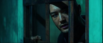 Movie still from “Escape Plan 2: Hades” (2018), directed by Steven C. Miller – A person behind a wooden fence; Close Up shot, Low angle