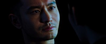 Movie still from “Escape Plan 2: Hades” (2018), directed by Steven C. Miller – A man's face in the dark; Close Up shot, Over the shoulder angle