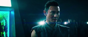 Movie still from “Escape Plan 2: Hades” (2018), directed by Steven C. Miller – A man in a black shirt is looking at the camera; Close Up shot, Low angle