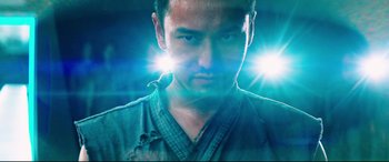 Movie still from “Escape Plan 2: Hades” (2018), directed by Steven C. Miller – A person wearing a green shirt; Close Up shot, Low angle