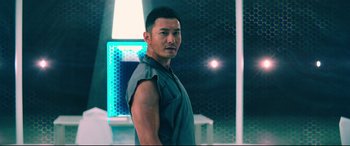 Movie still from “Escape Plan 2: Hades” (2018), directed by Steven C. Miller – A man in a blue shirt is posing for a picture; Close Up shot, Low angle