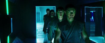 Movie still from “Escape Plan 2: Hades” (2018), directed by Steven C. Miller – A group of men standing next to each other in a room; Medium shot, Low angle