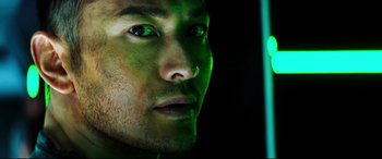 Movie still from “Escape Plan 2: Hades” (2018), directed by Steven C. Miller – A man's face in a green light; Extreme Close Up shot, Low angle