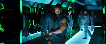 Movie still from “Escape Plan 2: Hades” (2018), directed by Steven C. Miller – A group of men standing next to each other in a room; Medium shot, Over the shoulder angle