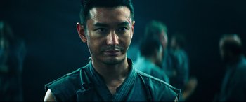 Movie still from “Escape Plan 2: Hades” (2018), directed by Steven C. Miller – A person wearing a robe; Close Up shot, Over the shoulder angle