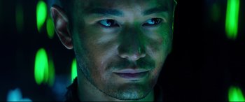 Movie still from “Escape Plan 2: Hades” (2018), directed by Steven C. Miller – A man's face with green light in the background; Close Up shot, High angle