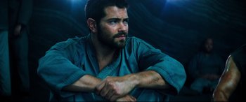 Movie still from “Escape Plan 2: Hades” (2018), directed by Steven C. Miller – A person wearing a robe; Close Up shot, Low angle