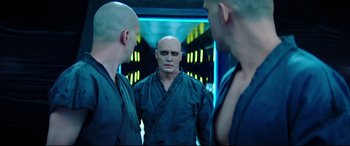 Movie still from “Escape Plan 2: Hades” (2018), directed by Steven C. Miller – A man with a bald head is looking at himself in the mirror; Close Up shot, Over the shoulder angle