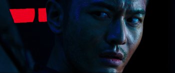 Movie still from “Escape Plan 2: Hades” (2018), directed by Steven C. Miller – A man's face with blue light shining on his face; Extreme Close Up shot, Low angle
