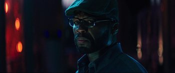 Movie still from “Escape Plan 2: Hades” (2018), directed by Steven C. Miller – A person wearing glasses and a hat; Close Up shot, Low angle