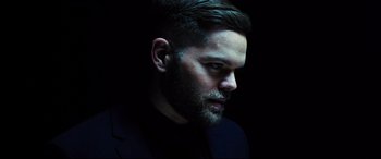 Movie still from “Escape Plan 2: Hades” (2018), directed by Steven C. Miller – A person wearing a suit and beard; Close Up shot, Low angle