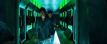 Movie still from “Escape Plan 2: Hades” (2018), directed by Steven C. Miller – Two men are standing in a tunnel with green lights; Wide shot, Low angle