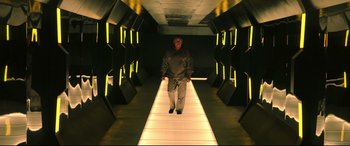 Movie still from “Escape Plan 2: Hades” (2018), directed by Steven C. Miller – A man walking down a ramp in a tunnel; Wide shot, Low angle