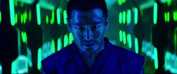 Movie still from “Escape Plan 2: Hades” (2018), directed by Steven C. Miller – A man in a blue robe stares at the camera; Close Up shot, Low angle