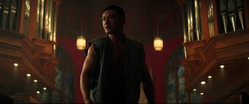 Movie still from “Escape Plan 2: Hades” (2018), directed by Steven C. Miller – A man standing in front of a wall in a dark room; Medium shot, Low angle