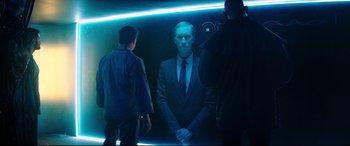 Movie still from “Escape Plan 2: Hades” (2018), directed by Steven C. Miller – A man in a suit and tie standing in front of a mirror; Medium shot, Over the shoulder angle