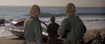 Movie still from “Escape from the Planet of the Apes” (1971), directed by Don Taylor – A group of men standing on top of a sandy beach; Wide shot, Over the shoulder angle
