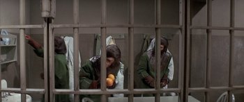 Movie still from “Escape from the Planet of the Apes” (1971), directed by Don Taylor – A woman holding two oranges in a jail cell; Medium shot, High angle