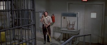 Movie still from “Escape from the Planet of the Apes” (1971), directed by Don Taylor – A man holding a broom and a fire extinguisher; Wide shot, High angle