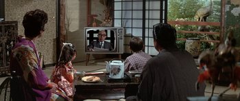 Movie still from “Escape from the Planet of the Apes” (1971), directed by Don Taylor – A group of people sitting in front of a television; Wide shot, Over the shoulder angle