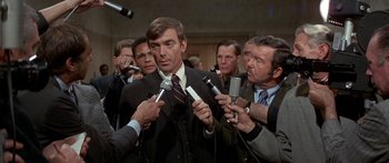 Movie still from “Escape from the Planet of the Apes” (1971), directed by Don Taylor – A group of men holding microphones in a room; Medium shot, Over the shoulder angle