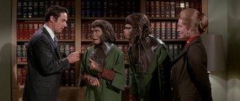 Movie still from “Escape from the Planet of the Apes” (1971), directed by Don Taylor – A couple of people that are dressed up like apes; Medium shot, Low angle