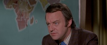 Movie still from “Escape from the Planet of the Apes” (1971), directed by Don Taylor – A man in a suit and tie looking at the camera; Close Up shot, High angle